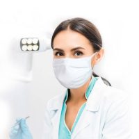 modelo da máscara de tecido tripla reutilizável da cerkamed colocado na face de uma médica dentista